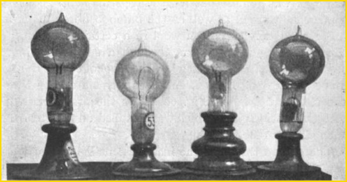 Close-up photograph of two early Thomas Edison incandescent light bulbs from 1879, showcasing the distinctive horseshoe-shaped paper filaments inside the glass globes.
